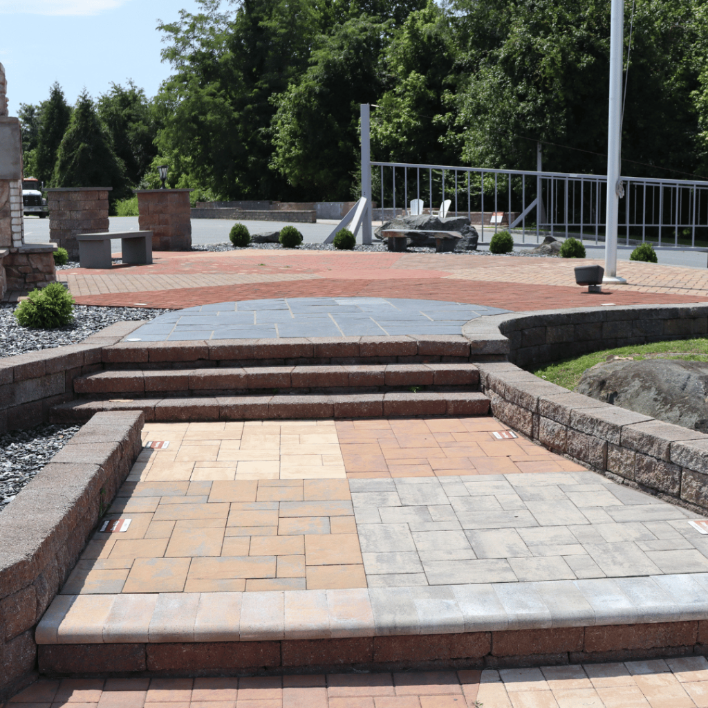 Outdoor showroom patio with block steps and a two-tone paver pattern